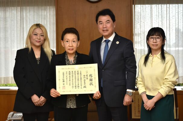 佐藤市長(右から2人目)から感謝状を贈られた中川さん(同3人目)ら