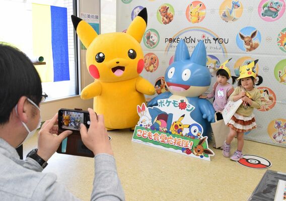 「那須こども食堂ザ・テーブル」を訪問したピカチュウと記念撮影する子どもたち