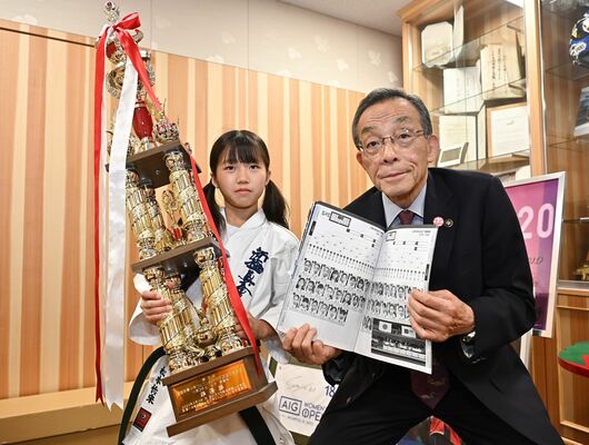トロフィーを手にする松本さん（左）