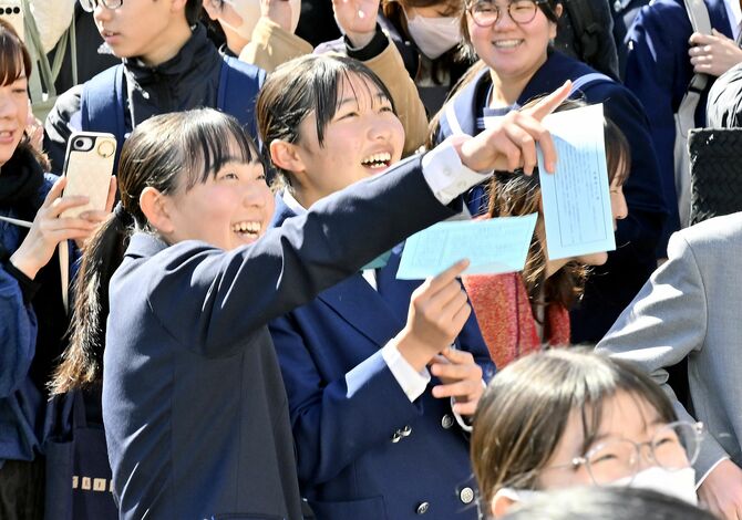 受験番号を見つけ笑顔を見せる受験生＝11日午前10時、宇都宮市若草２丁目