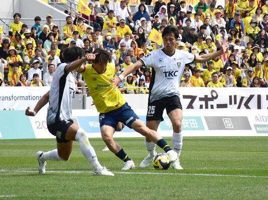 前半、相手選手と競り合う栃木ＳＣのＤＦ岩崎（右）＝ミクニワールドスタジアム北九州