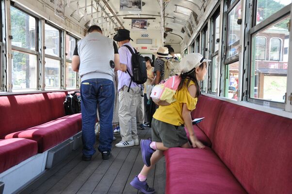 公開された路面電車の中を見学する観光客