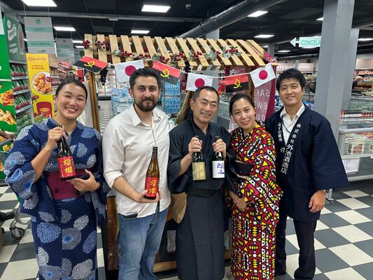 首都・ルアンダの高級スーパーで日本酒試飲会を開いた外池社長（中央）や大使館職員＝３月１４日