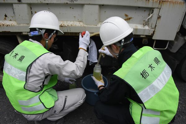 分析用の燃料を抜き取る職員