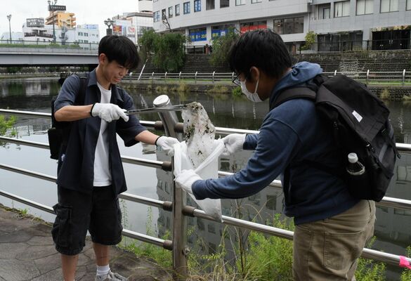 田川遊歩道でごみを拾う参加者