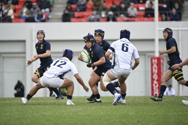 前半ロスタイム、国学栃木のナンバーエイト椎名（中央）が突破を図る＝花園ラグビー場、森田大地撮影