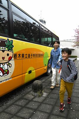 通学バスに乗り込む奏明さん（右）と恵さん＝４月、真岡市内