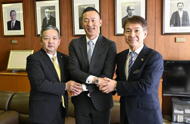 交付式で早川市長（右）や大島教育長（左）と握手する岡田さん