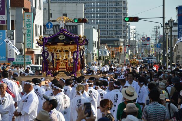 かけ声とともに令和神輿を担ぐ参加者たち