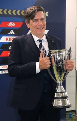 　サッカー女子日本代表のアジア・カップ優勝報告の記者会見で、笑顔で優勝カップを持つニールセン監督＝２３日、東京都文京区