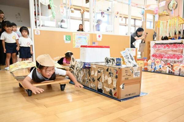 ベトナムに見立てた教室で川を渡るごっこ遊びを楽しむ園児