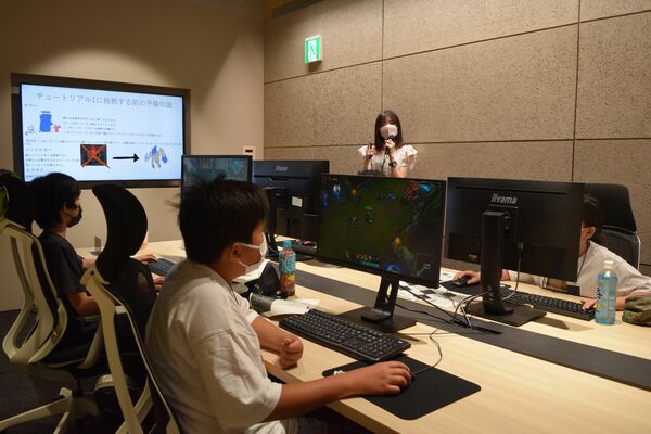 プロゲーマーに教えてもらいながら、ｅスポーツを体験する中高生たち＝７月上旬、前橋市内