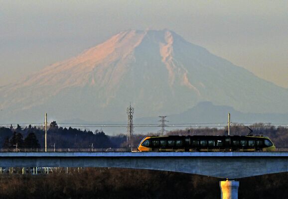 朝日を受けほんのり赤く染まる富士山と鬼怒川を渡る列車＝12日午前７時５分、宇都宮市道場宿町（超望遠レンズ使用）