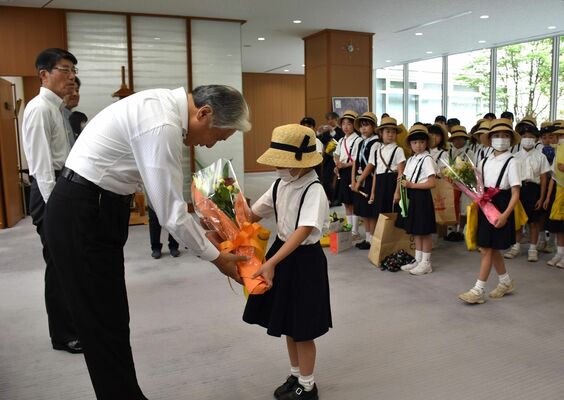 福田知事（左）に花束を手渡す作新学院小学部の児童＝８日午前、県庁