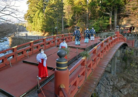笹竹で神橋のほこりを払う神職ら＝12日午前９時10分、日光市上鉢石町