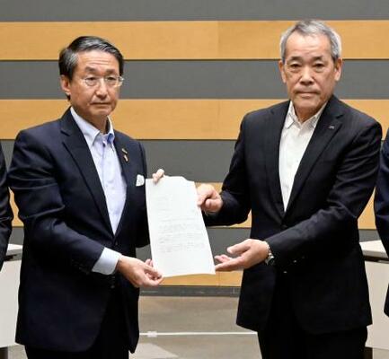 中国電力から島根原発2号機のプルサーマル発電についての文書を受け取る平井伸治鳥取県知事(左)=24日午前、鳥取県境港市
