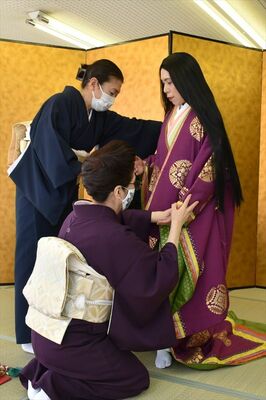 十二単を着せてもらう参加者（右）