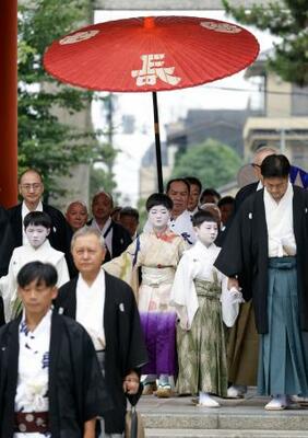　京都・祇園祭の無事を祈願する「お千度の儀」で、八坂神社を参拝する稚児の長谷航太郎さん（中央）ら＝１日午前、京都市東山区