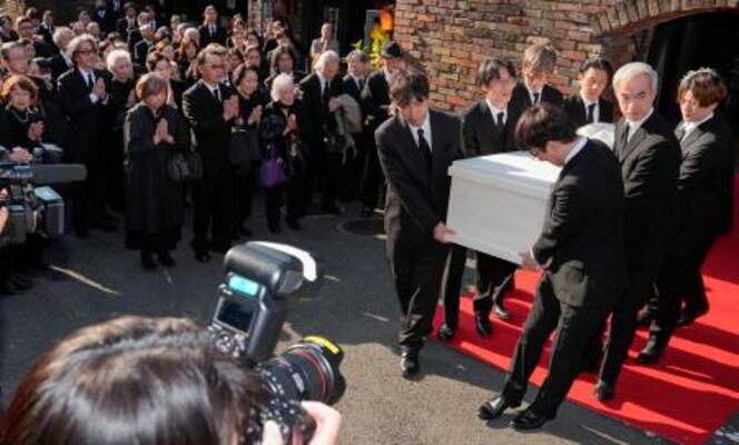 出棺のため関係者に運ばれる仲代達矢さんのひつぎ。参列する役所広司さん(左奥)の姿もあった=14日午後、東京都世田谷区