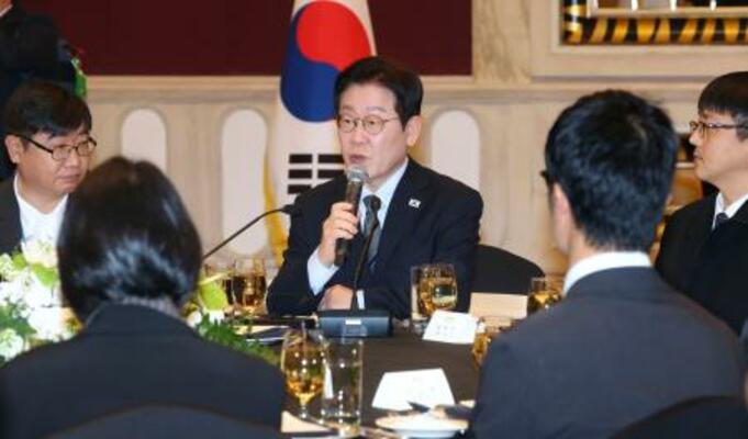 　７日、中国・上海で記者団と懇談する韓国の李在明大統領（中央）（聯合＝共同）