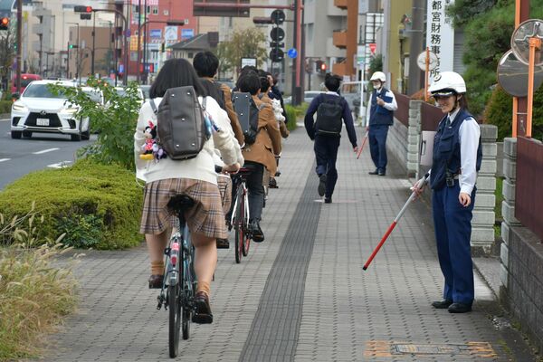 高校生らの下校時間帯に自転車の取り締まりなどを行う宇都宮中央署員ら＝11月上旬、宇都宮市桜３丁目