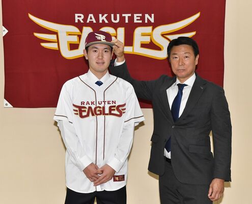 楽天のユニホームに袖を通す中沢(左)=白鴎大