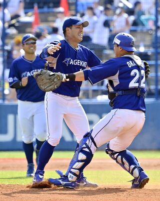 ５安打１失点で完投したエイジェックの金城（中央）が捕手・岡島（右）と抱き合って喜ぶ＝群馬県太田市運動公園野球場