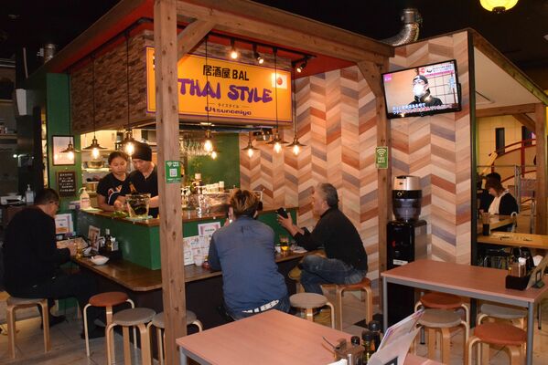 通路にも飲食スペースが出された屋内型屋台村「夜市横丁」＝８日夜、宇都宮市