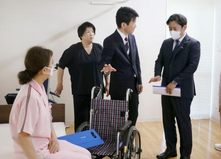 特別養護老人ホーム「サンシティ北条」で、介護の取り組みについて説明を受ける福岡厚労相(右端)=16日午後、松山市