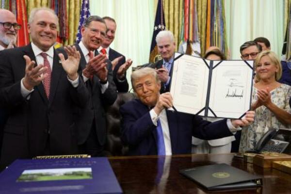 米ホワイトハウスで、不法移民対策費用を確保する内容の法案に署名したトランプ大統領(中央)=10日(ゲッティ=共同)