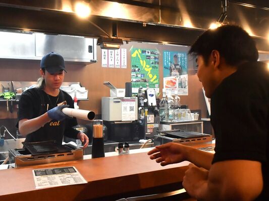 オリオン通り周辺の店舗にポスターを配布するバックスの早田選手（右）＝宇都宮市内