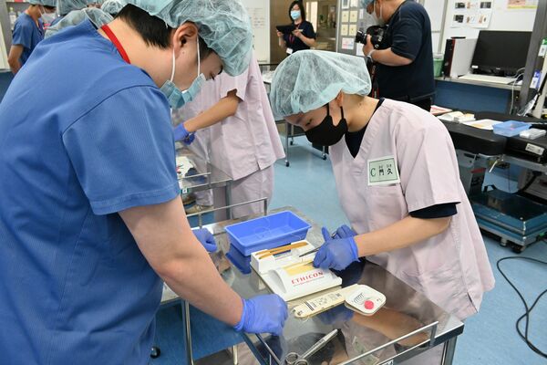 縫合を体験する高校生(右)