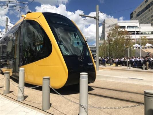 関係者を乗せ、宇都宮駅東口停留所を出発した記念運行の列車＝26日午前11時42分、宇都宮市