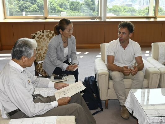 福田知事（左端）と面会するダミアンさん（右端）＝25日午前、県庁