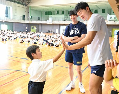 星川選手（右）、小川選手（中央）と手の大きさ比べをする児童