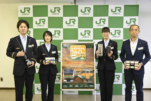 記念商品などを手にするＪＲ東日本の担当者と石井支社長（右）＝１３日正午、宇都宮市