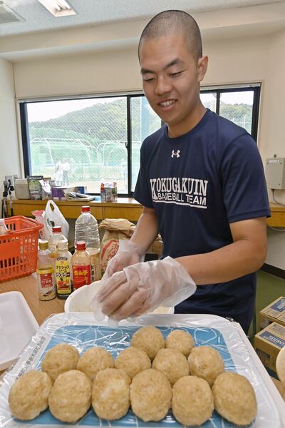 味付けにこだわり補食のおにぎりを握る印口=国学栃木高野球場、永嶌理絵撮影