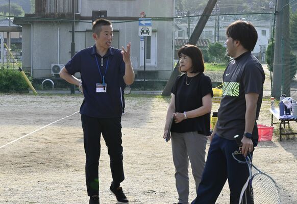 ソフトテニス部を視察する岡田さん（左）