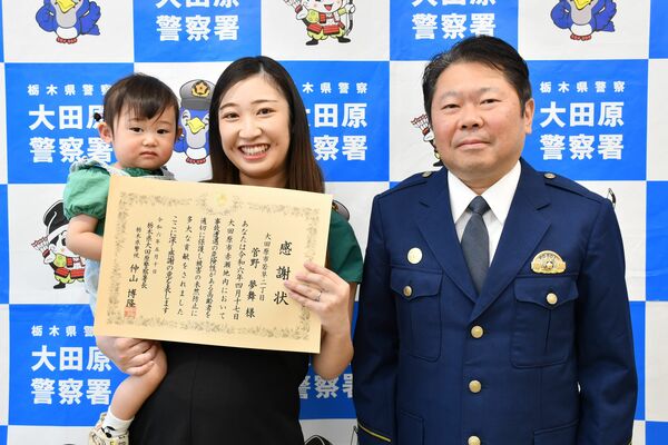 仲山署長（右）から感謝状を受け取った菅野さん（中央）