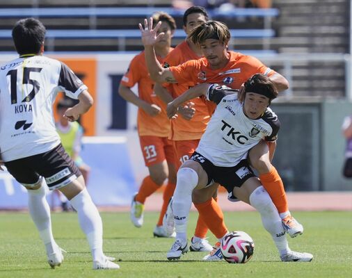 前半、ボールを奪う栃木ＳＣのＭＦ神戸（右手前）＝松山市のニンジニアスタジアム