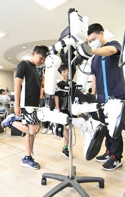 身体機能の改善をサポートする装着型ロボットスーツ「ＨＡＬ（ハル）」を体験する市内の小学生ら