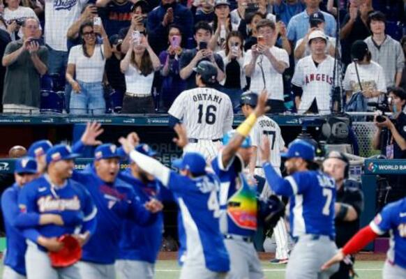 9回、遊飛に倒れて最後の打者となった大谷(16)。手前は日本に勝利し喜ぶベネズエラの選手たち=マイアミ(共同)