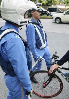 　危険な走行をしていた自転車を止めて指導する警視庁の警察官＝２０２４年、東京都千代田区