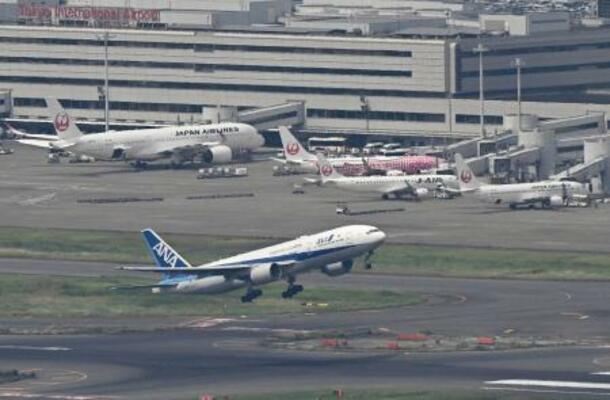 羽田空港を離陸する全日空機と駐機する日航機=4日午後(共同通信社ヘリから)