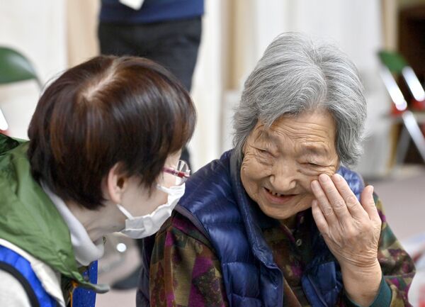 避難所を訪問したボランティアが被災者の女性（右）に「肌がきれいね」と話しかけると、女性は頬に手を当て、うれしそうに笑顔で応えた＝２月28日午前11時10分、石川県穴水町