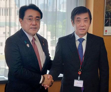 赤沢経済再生相(左)と握手する日本自動車工業会の片山正則会長=17日午前、東京都千代田区