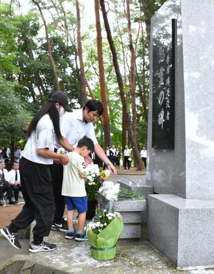 慰霊碑に献花する参列者＝24日午前、宇都宮市西川田４丁目