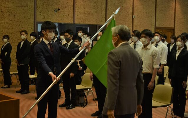 福田知事（右）から県旗を受け取る選手代表＝14日午後、県公館