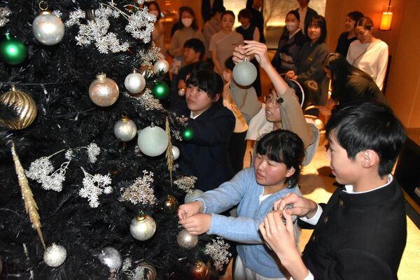 クリスマスツリーを飾り付ける児童生徒ら