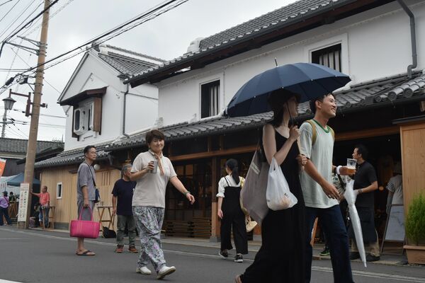 ビールを片手に嘉右衛門町を歩く来場者